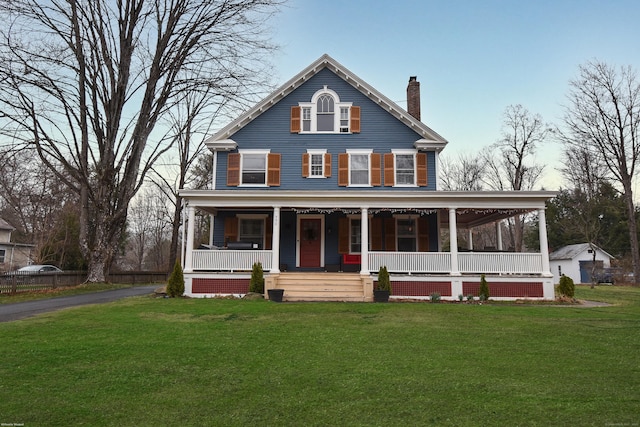 view of front of house with a porch, a chimney, and a front yard