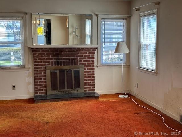 94 Morris St, West Haven, CT 06516 - unfurnished living room featuring baseboards, a brick fireplace, and a wealth of natural light