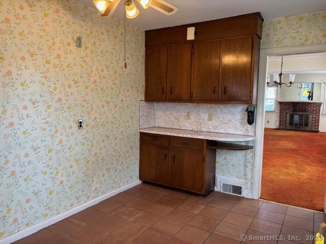 94 Morris St, West Haven, CT 06516 - kitchen with wallpapered walls, a ceiling fan, light countertops, and baseboards
