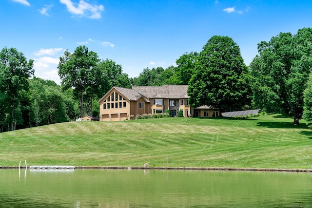 exterior space with an attached garage, a yard, and a water view