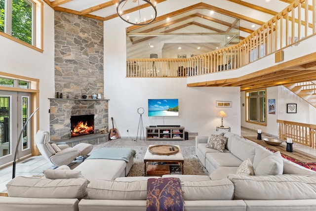 living area with high vaulted ceiling, a fireplace, beamed ceiling, and plenty of natural light