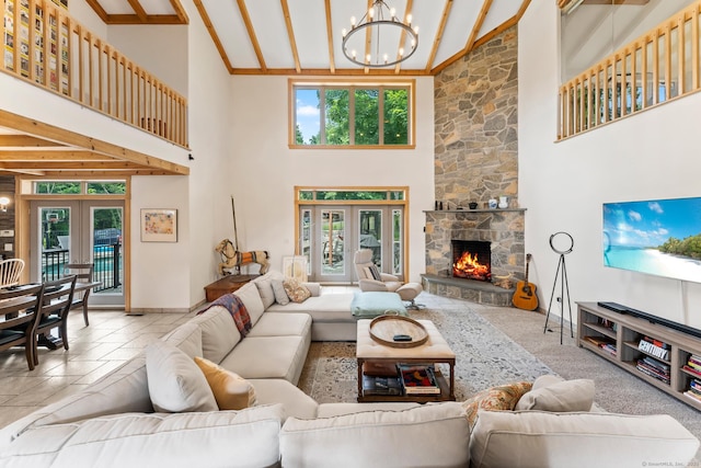 living room with high vaulted ceiling, a stone fireplace, an inviting chandelier, french doors, and baseboards