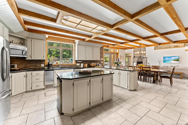 kitchen featuring a center island, a sink, appliances with stainless steel finishes, and a healthy amount of sunlight