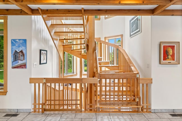 stairs featuring baseboards, visible vents, and tile patterned flooring