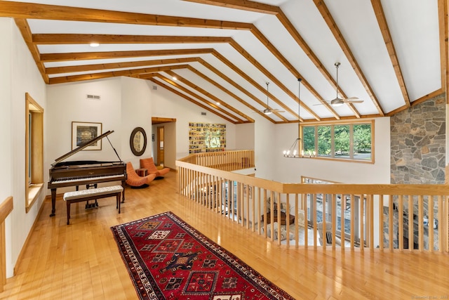 hall with high vaulted ceiling, wood finished floors, and visible vents