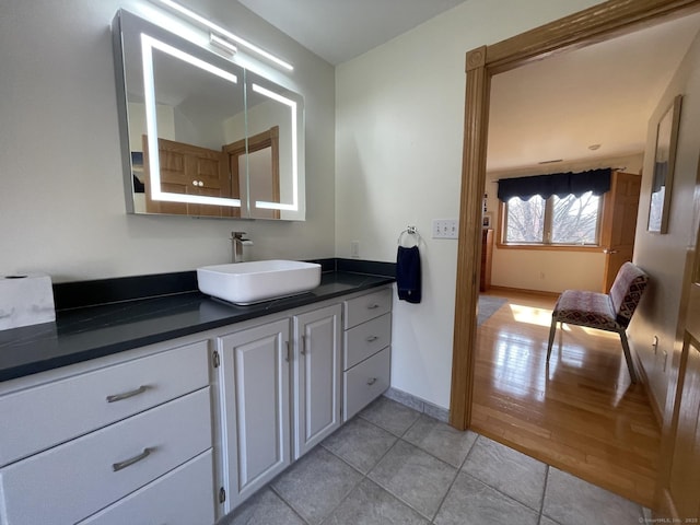 bathroom with vanity, baseboards, and tile patterned flooring