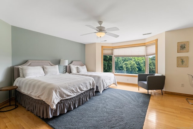 bedroom featuring light wood-style floors, a ceiling fan, and baseboards
