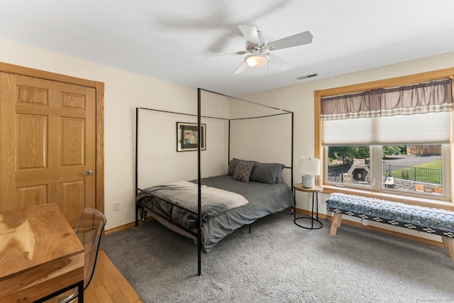 bedroom with wood finished floors, visible vents, baseboards, and ceiling fan