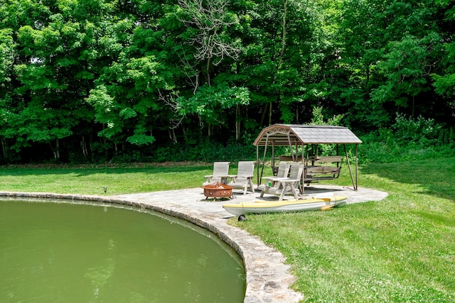 view of home's community with a yard and an outdoor fire pit