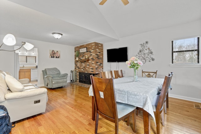 dining space with baseboards, light wood-type flooring, a ceiling fan, radiator, and vaulted ceiling