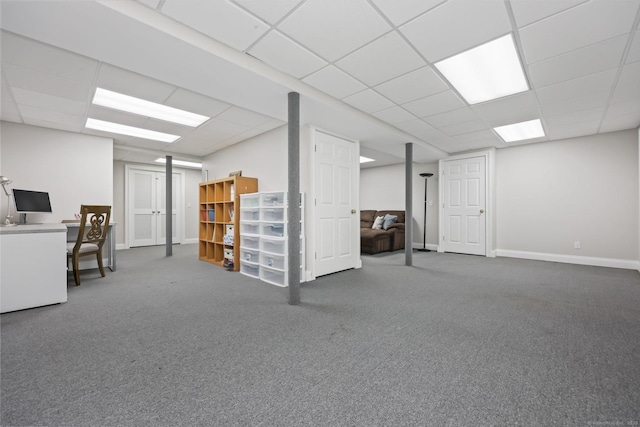 finished basement featuring a drop ceiling, baseboards, and carpet floors