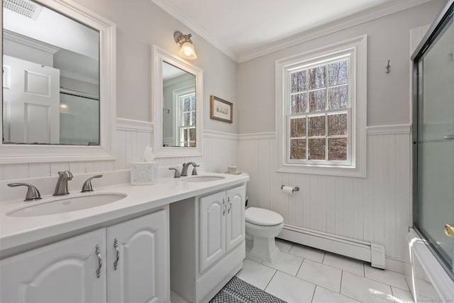 bathroom featuring a sink, a baseboard heating unit, and wainscoting
