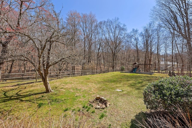 view of yard featuring fence and a playground
