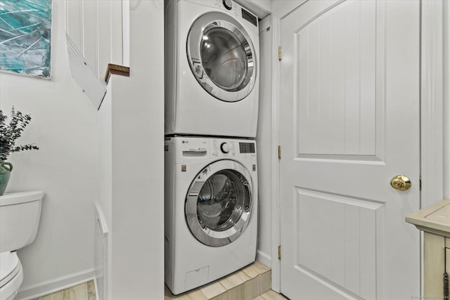 231 Pawson Rd, Branford, CT 06405 - laundry room with stacked washer / drying machine, light wood-style floors, and baseboards