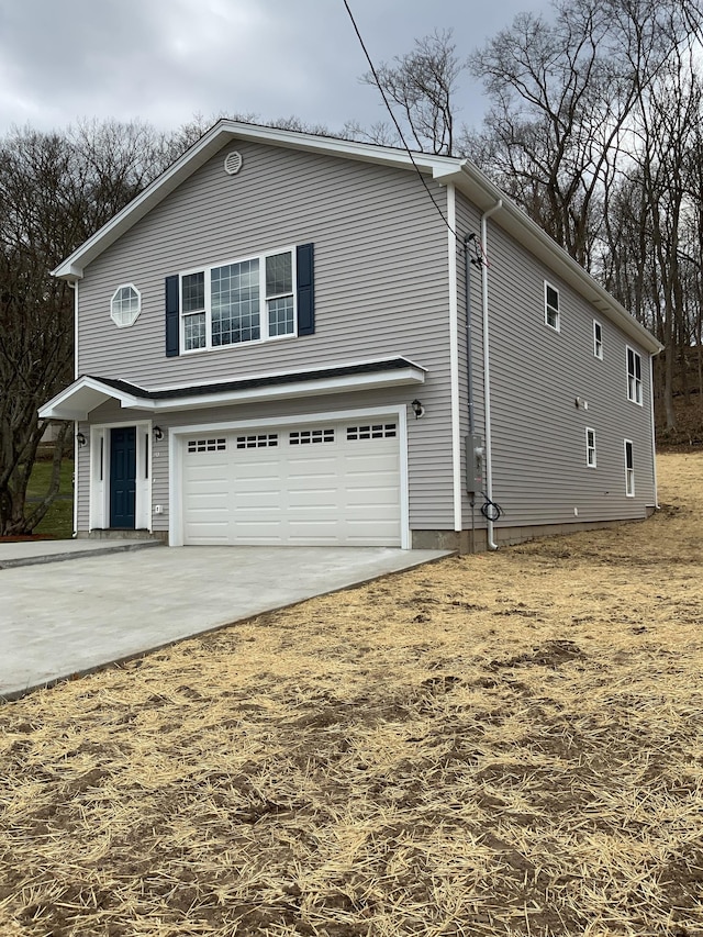 view of property exterior featuring driveway and a garage