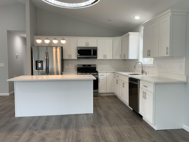 kitchen featuring stainless steel appliances, a sink, white cabinetry, lofted ceiling, and decorative backsplash