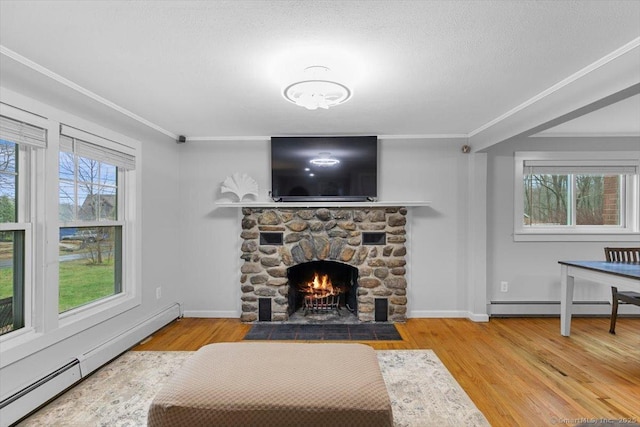 living area with ornamental molding, a fireplace, wood finished floors, and baseboard heating