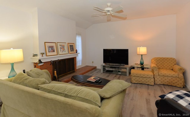 living area featuring baseboards, lofted ceiling, wood finished floors, and a ceiling fan
