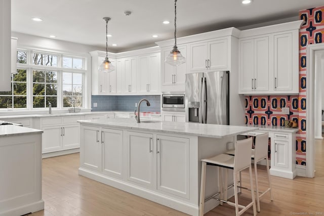 3 Mayflower Ln, Weston, CT 06883 - kitchen featuring tasteful backsplash, white cabinets, a sink, a kitchen island with sink, and stainless steel appliances