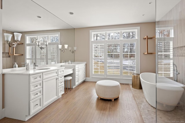 3 Mayflower Ln, Weston, CT 06883 - bathroom featuring a freestanding tub, vanity, an inviting chandelier, a healthy amount of sunlight, and wood finished floors