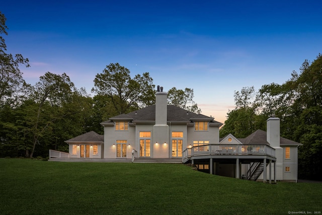 3 Mayflower Ln, Weston, CT 06883 - back of property at dusk featuring a shingled roof, a deck, a lawn, a chimney, and stairs