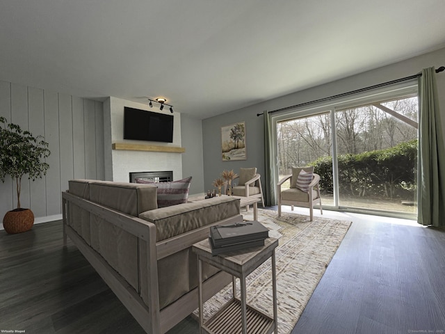 living area featuring a wealth of natural light, a fireplace, and wood finished floors