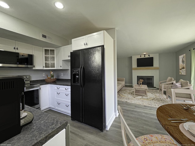 kitchen with dark countertops, visible vents, white cabinetry, and stainless steel appliances