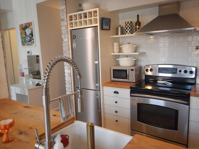 134 Washington St Apt 201, Norwalk, CT 06854 - kitchen featuring appliances with stainless steel finishes, wall chimney range hood, wood counters, open shelves, and backsplash