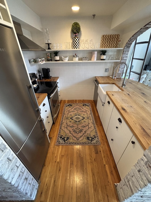 134 Washington St Apt 201, Norwalk, CT 06854 - kitchen featuring butcher block counters, open shelves, light wood finished floors, and white cabinets