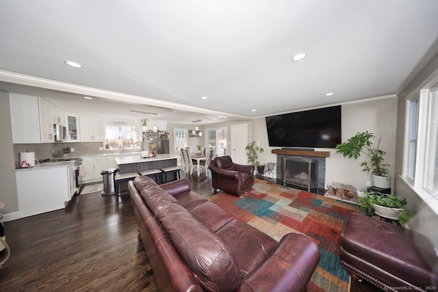 living room with recessed lighting, dark wood finished floors, and a fireplace with flush hearth