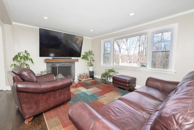 living room with recessed lighting, wood finished floors, crown molding, baseboards, and a fireplace