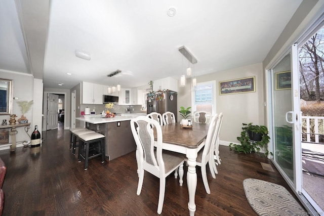 dining area featuring baseboards, a healthy amount of sunlight, dark wood-type flooring, and recessed lighting