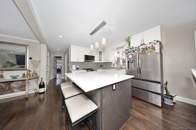 kitchen featuring stainless steel appliances, light countertops, dark wood-style floors, and white cabinetry