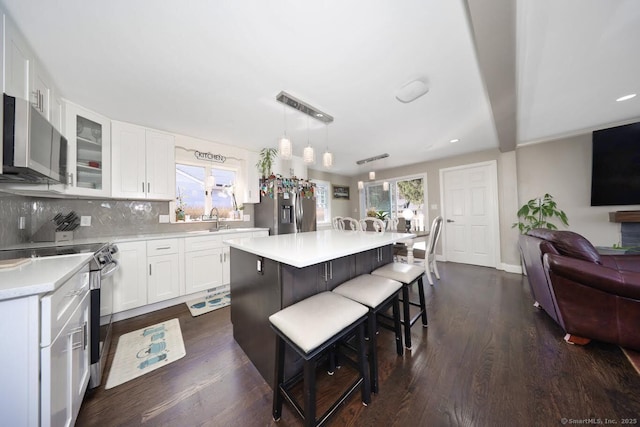 kitchen with light countertops, a kitchen bar, a healthy amount of sunlight, and appliances with stainless steel finishes