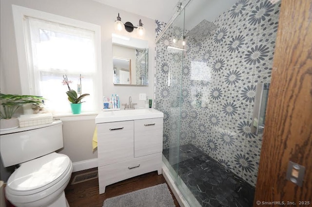 full bath with a shower stall, wood finished floors, vanity, toilet, and visible vents