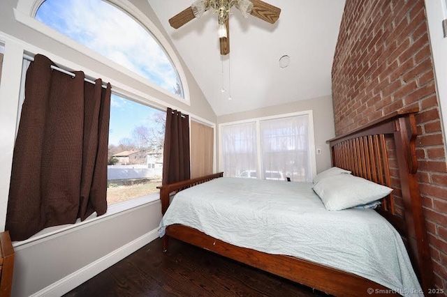 bedroom featuring baseboards, wood finished floors, high vaulted ceiling, and ceiling fan