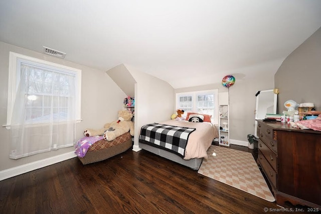 bedroom featuring baseboards, lofted ceiling, wood finished floors, and visible vents