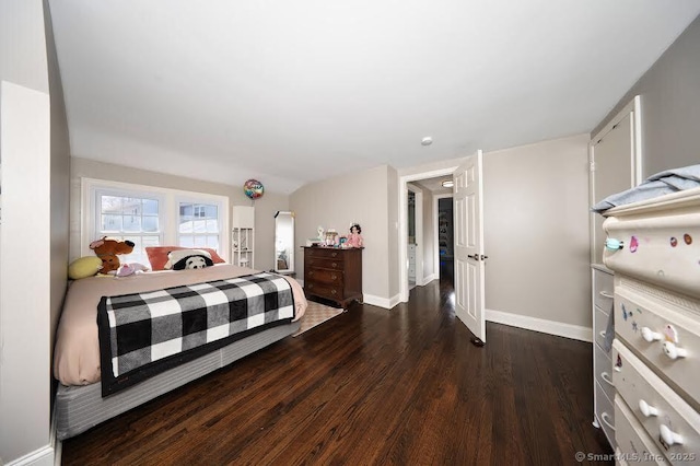 bedroom featuring baseboards and dark wood-type flooring