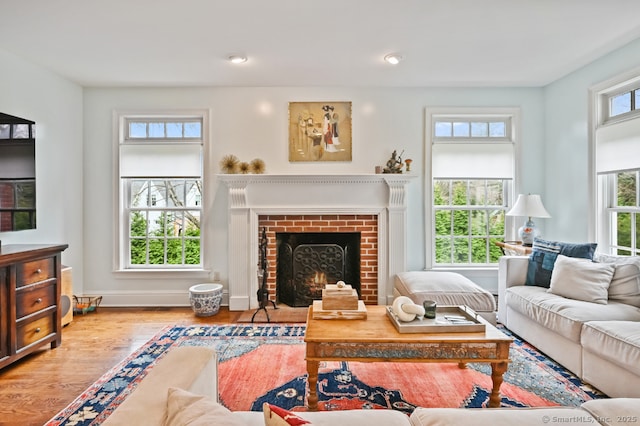 living room with baseboards, a brick fireplace, wood finished floors, and recessed lighting
