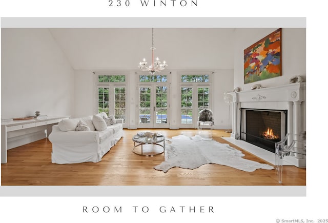 living area featuring a fireplace with flush hearth, wood finished floors, and a wealth of natural light