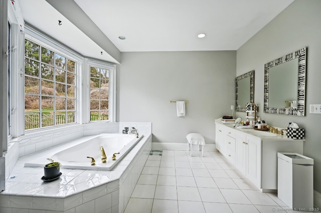 bathroom featuring a bath, baseboards, vanity, and tile patterned floors