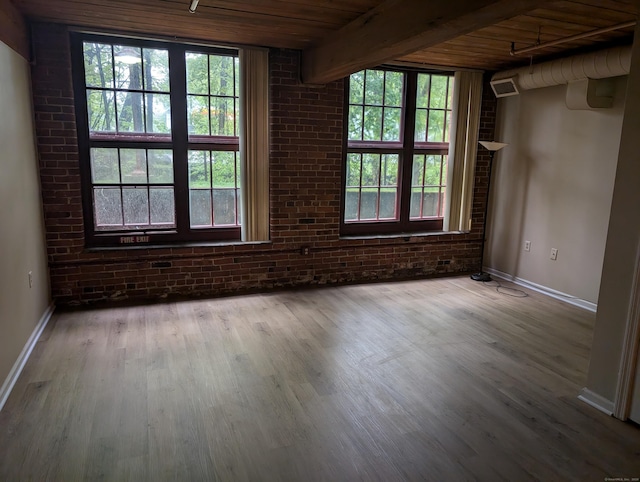 839 Main St Apt 28, Torrington, CT 06790 - unfurnished room featuring wooden ceiling, healthy amount of natural light, baseboards, wood finished floors, and brick wall