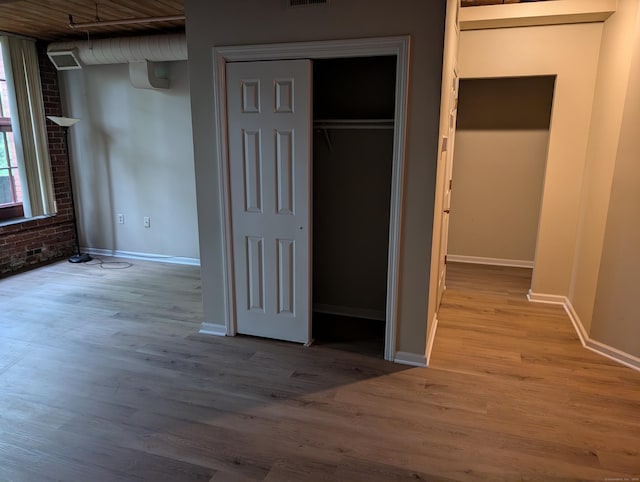 839 Main St Apt 28, Torrington, CT 06790 - unfurnished bedroom with brick wall, wood finished floors, and baseboards