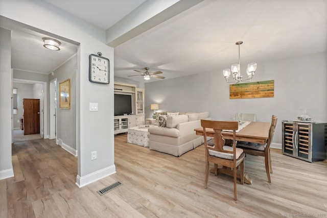 76 Carriage Path S Unit 76, Milford, CT 06460 - dining room with light wood-style flooring, visible vents, baseboards, ceiling fan with notable chandelier, and beverage cooler