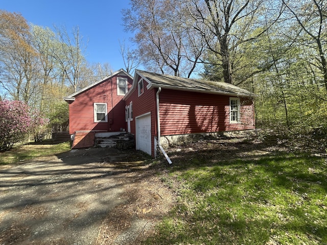 view of side of property featuring driveway and an attached garage