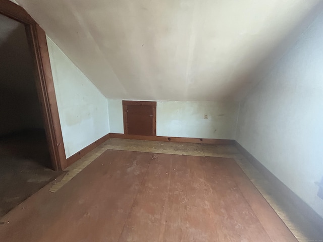 bonus room featuring baseboards, wood finished floors, and vaulted ceiling