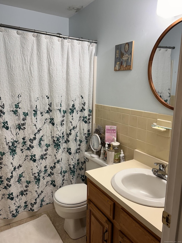 bathroom featuring a shower with curtain, tile walls, tile patterned floors, vanity, and toilet