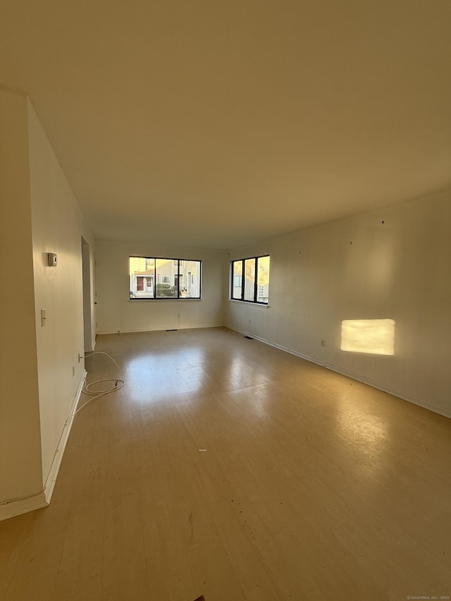 empty room with baseboards and light wood-style flooring