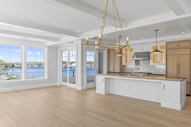 22 W Main St Unit 3, Groton, CT 06355 - kitchen with tasteful backsplash, beam ceiling, a sink, light wood finished floors, and under cabinet range hood