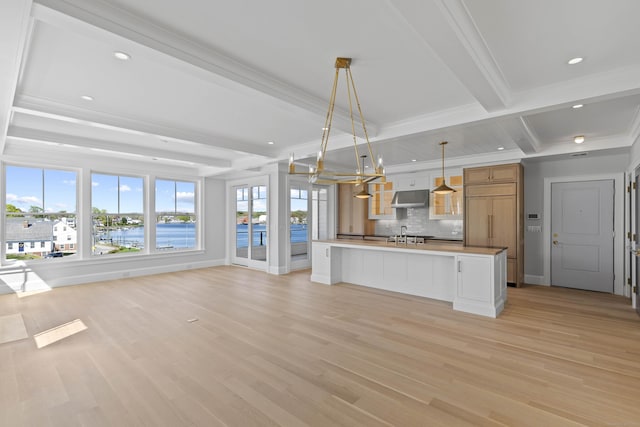 22 W Main St Unit 3, Groton, CT 06355 - kitchen featuring tasteful backsplash, beamed ceiling, under cabinet range hood, and light wood-style flooring